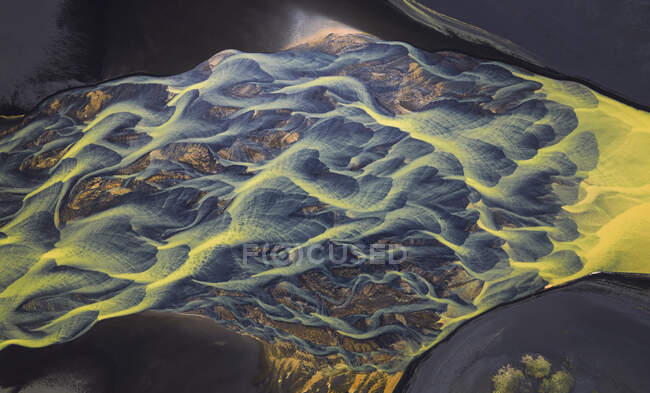 Vue aérienne de la rivière avec de l'eau orange traversant une campagne agitée en Islande — Photo de stock