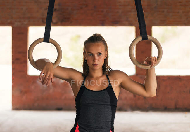 Портрет спортсменки с гимнастическими кольцами, смотрящей в камеру — стоковое фото