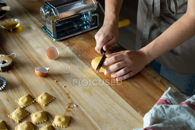 Unrecognizable person preparing raviolis and pasta at home. She is cutting the pasta plates — Stock Photo