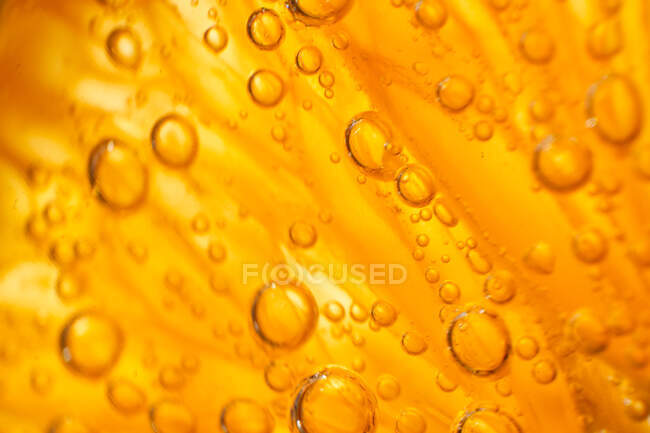 Крупный план джин-тоник с кусочком свежего апельсина, пузырящимся в стекле — стоковое фото