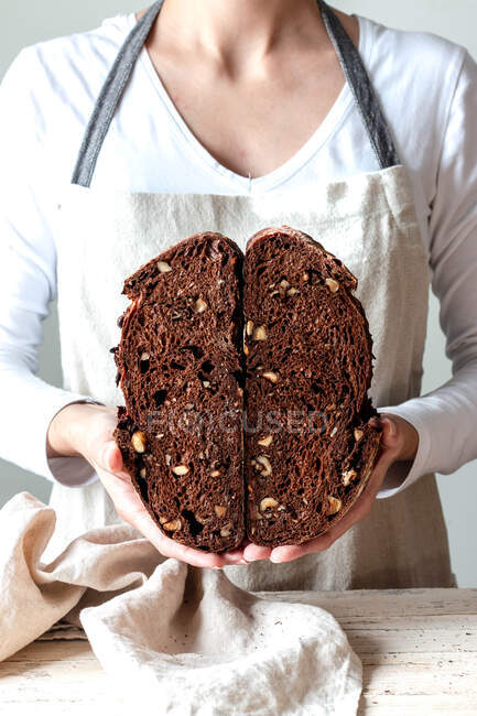 Cortar as mãos mulher sem rosto segurando pão de centeio fervido na hora pão migalha panela de corte ao meio — Fotografia de Stock