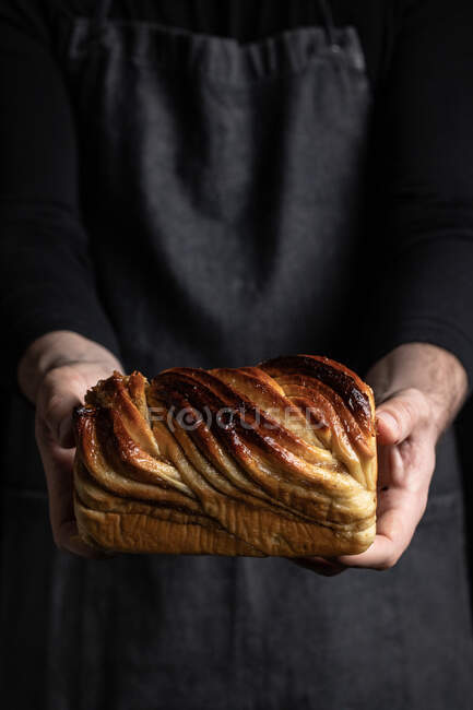 Unbekannter Mann in schwarzer Schürze steht mit hausgemachtem Schoko-Babka-Dessert — Stockfoto