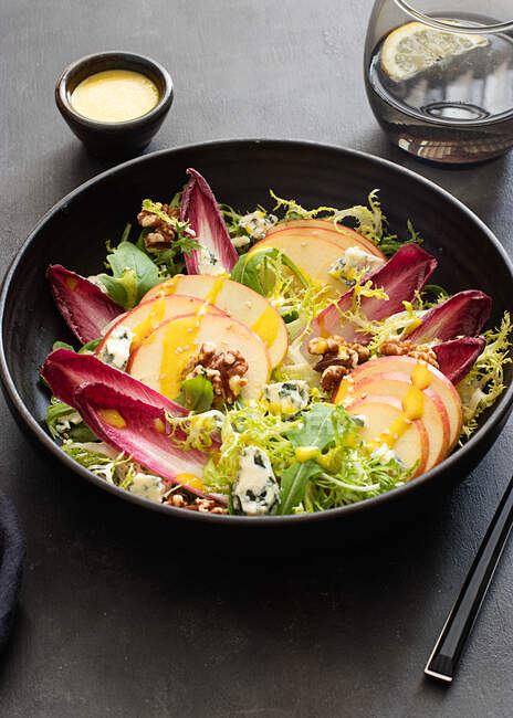 D'en haut délicieuse salade colorée avec endives, pomme et fromage roquefort sur fond sombre — Photo de stock