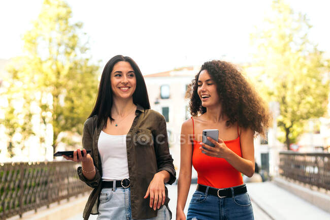 Casal de amigos usando seus celulares na rua — Fotografia de Stock