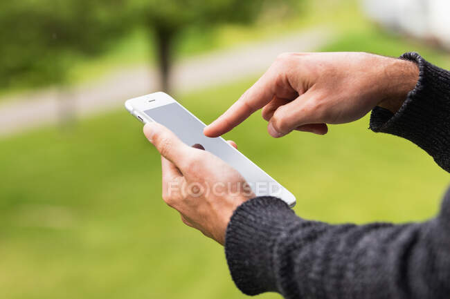 Нерозпізнаний самець, який читає смартфон, холоне на терасах Піренеїв. — стокове фото