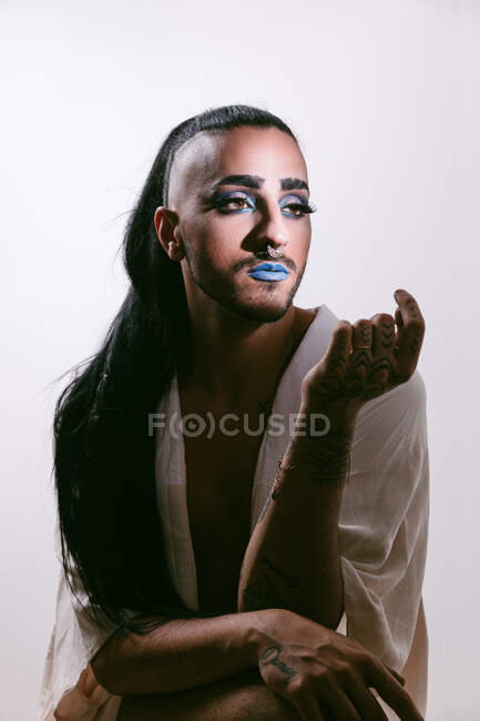 Ritratto di donna barbuta transgender glamour in sofisticato fanno guardando lontano sullo sfondo neutro — Foto stock