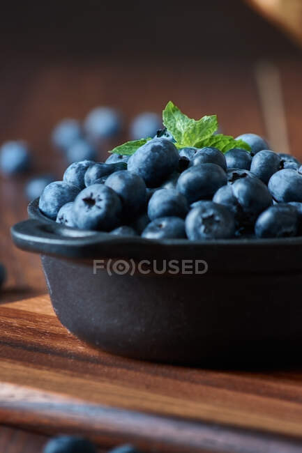 Detail of blueberries in a bowl on the wooden table — Stock Photo