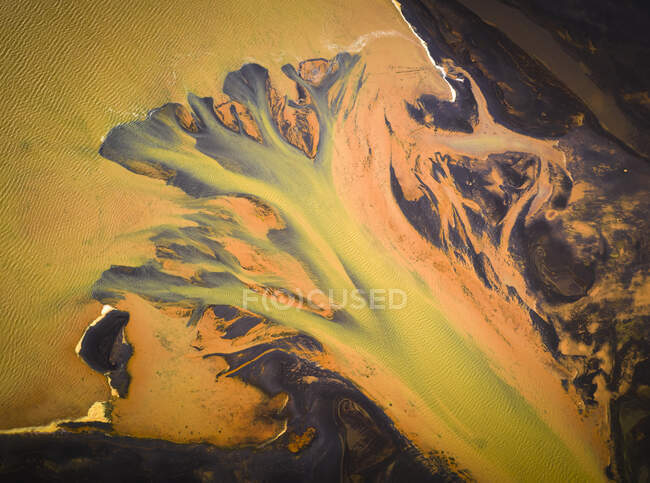 From above aerial view of river with orange water flowing through rough countryside in Iceland — Stock Photo