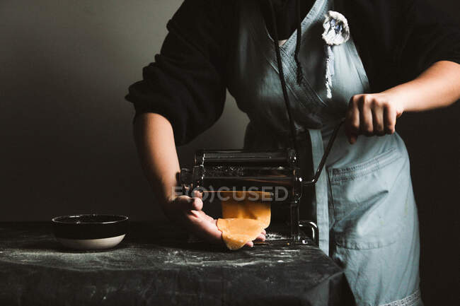 Personne méconnaissable préparant des raviolis et des pâtes à la maison. Elle utilise une machine à pâtes — Photo de stock