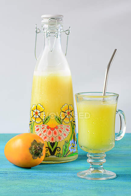 Передній вигляд кокосового соку в склянці і скляній пляшці на столі — стокове фото