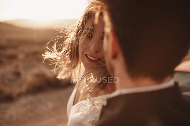 Unrecognizable man in suit embracing woman looking at each other during wedding celebration in Bardenas Reales Natural Park in Navarra, Spain — Stock Photo