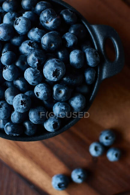 Vue du dessus des bleuets dans un bol sur la table en bois — Photo de stock