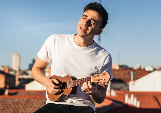Молодой человек играет на крыше — стоковое фото