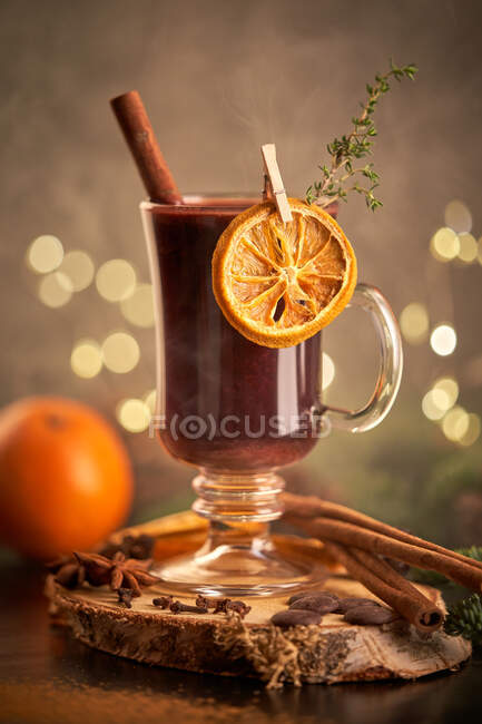 Serveur de vin paillé Gluhwein ou christmas punch sur une tasse en verre avec tranches d'orange séchées — Photo de stock