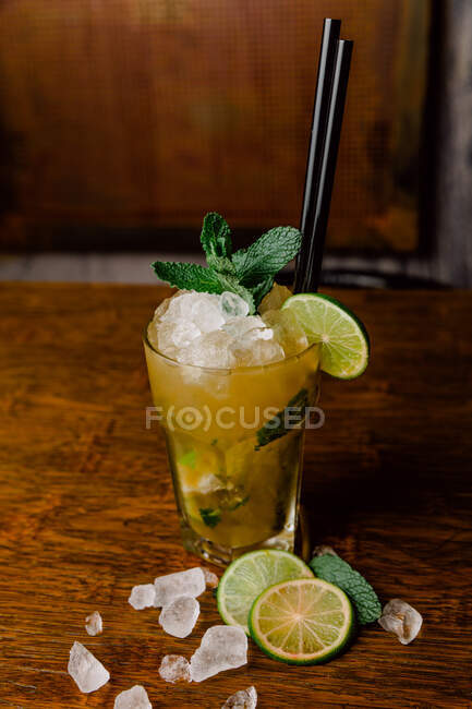 Bicchiere di cristallo di Mojito cocktail fatto di rum mescolato con succo di lime zucchero e acqua gassata guarnito con foglie di menta — Foto stock