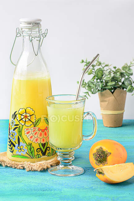 Вид спереди сока кокосы в стакане и стеклянной бутылке на столе — стоковое фото