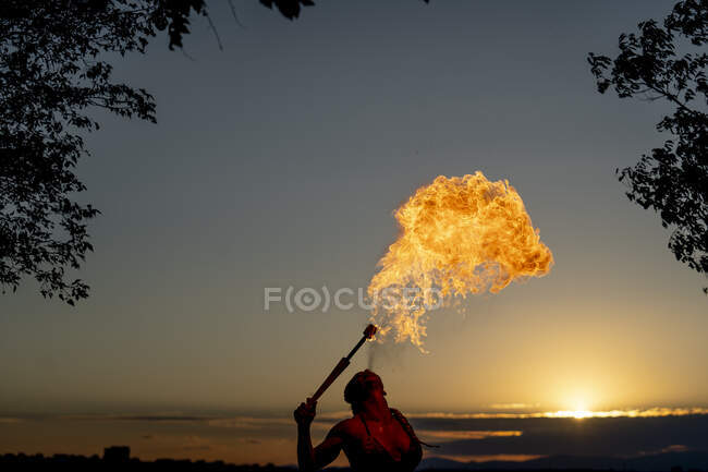 Пожирательница огня на закате — стоковое фото