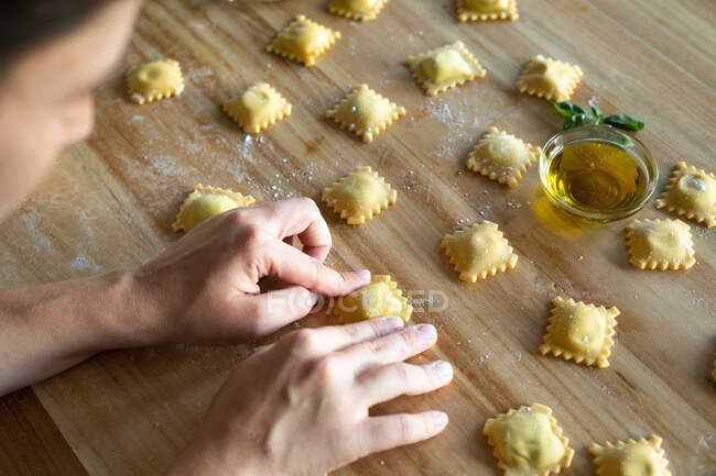 Unrecognizable person preparing raviolis and pasta at home. She is mounting the raviolis — Stock Photo