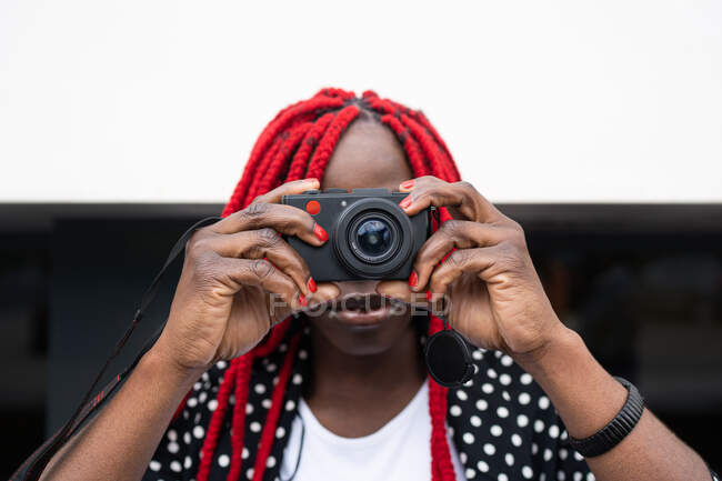 Afro-americano com cabelo vermelho tirando foto na câmera fotográfica — Fotografia de Stock