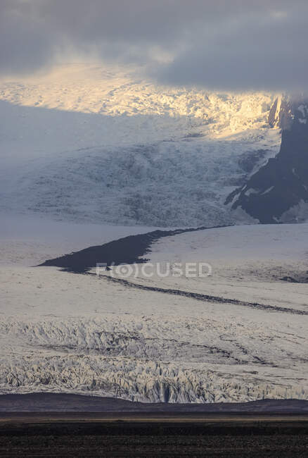 Pendiente de montaña cubierta de nieve blanca temprano en la mañana en invierno en Islandia - foto de stock