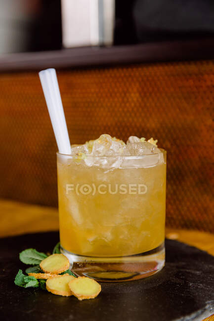 Glass of sour Yuzu Spice cocktail made of alcohol and juice served with pieces of ginger — Stock Photo