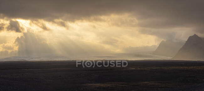 Гірський хребет, розташований на тлі хмарного сходу сонця в туманному ранкові в сільській місцевості Ісландії. — стокове фото