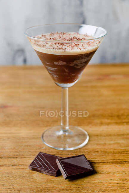 Glas süßer alkoholischer Cocktail aus Espressomaschine und Schokolade auf Holztisch — Stockfoto