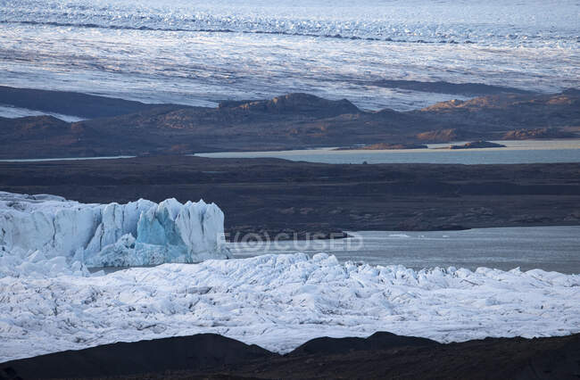Живописный вид ледника, покрывающего грубый берег холодного моря зимой в Исландии — стоковое фото