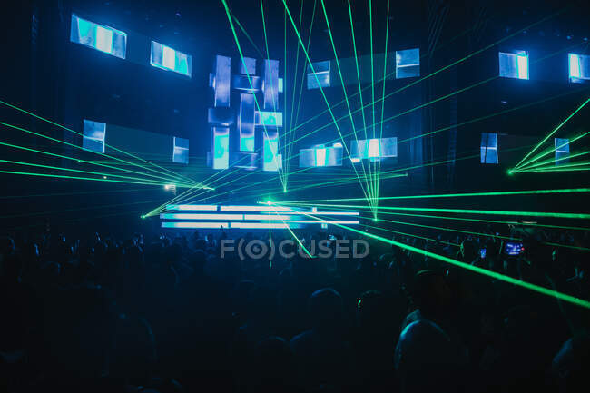 Luminosi raggi verdi al neon illuminano la moderna sala da concerto scura durante la performance musicale dal vivo — Foto stock