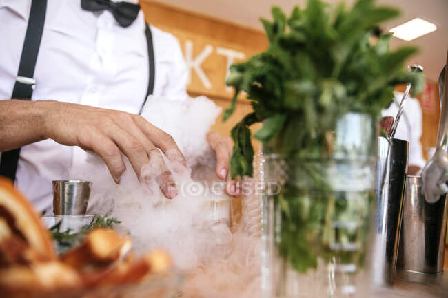 Ritaglia cameriere irriconoscibile in uniforme che serve bevande alcoliche sul tavolo durante l'evento festivo — Foto stock