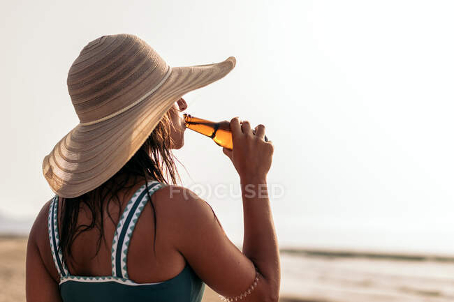 Погляд на анонімну самицю в сонячному капелюсі, яка п 