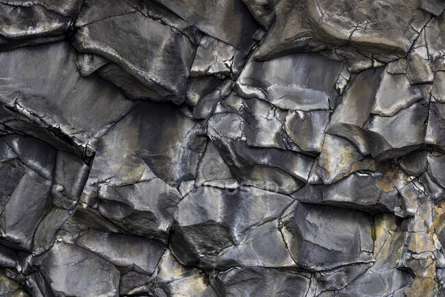 Superficie irregolare di ruvida falesia costituita da pietra nera dura in natura in Islanda — Foto stock