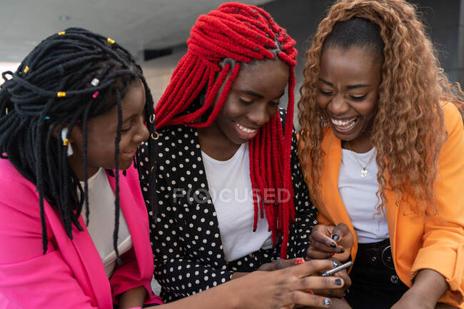 High angle of African American best friends sitting and browsing mobile phone — Stock Photo