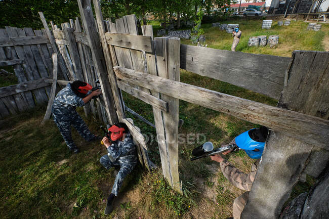 From above of teams with players in camouflage clothes playing paintball and aiming at other during game — Stock Photo