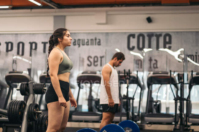 Hombre y mujer atleta entrenamiento deadlift en un gimnasio - foto de stock