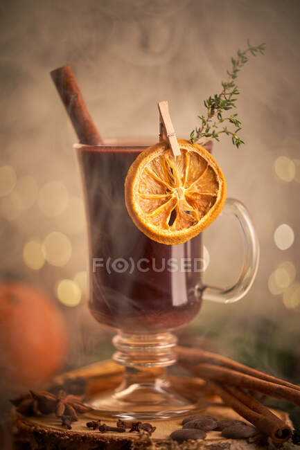 Gluhwein or christmas punch mulled wine server on a glass mug with dried orange slices — Stock Photo