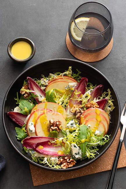 D'en haut délicieuse salade colorée avec endives, pomme et fromage roquefort sur fond sombre — Photo de stock
