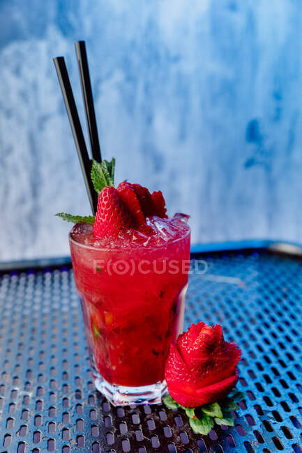 Transparent glass of Strawberry Mojito cocktail made of white rum soda water and mint leaves with straw — Stock Photo