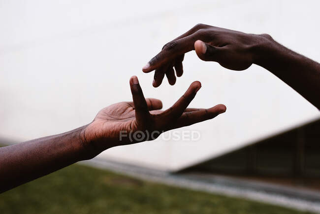Crop unrecognizable African American people reaching hands to each other for unity support and help — Stock Photo