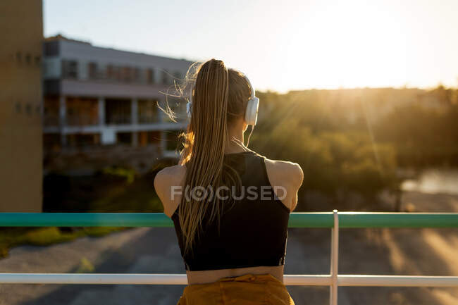 Young athletic caucasian leaning on banister stretching outdoors near road — Stock Photo