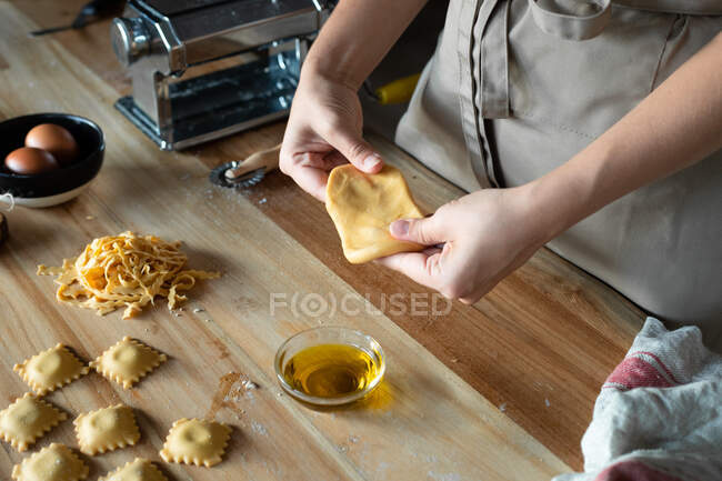 Unrecognizable person preparing raviolis and pasta at home. She is shaping the dough — Stock Photo
