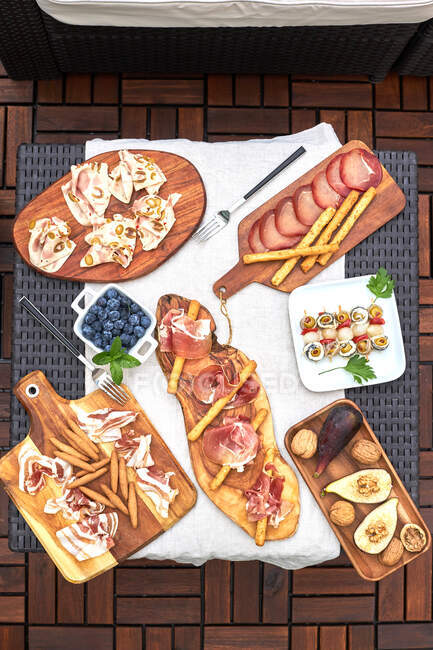 Table set up on a terrace with various delicious appetizers such as serrano ham, skewered pickled , nuts, etc — Stock Photo