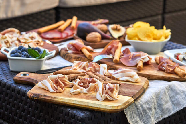 Hohe Winkel von köstlichen aufgespießten eingelegtem Gemüse mit Sardinen, Oliven, Paprika und Baby-Zwiebeln auf den Tisch mit Snack-Sortiment platziert — Stockfoto