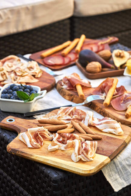 From above of assorted tasty appetizers served on table with tablecloth on terrace — Stock Photo