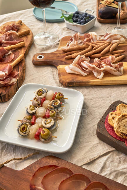Сверху разнообразные вкусные закуски подаются на столе со скатертью на террасе — стоковое фото