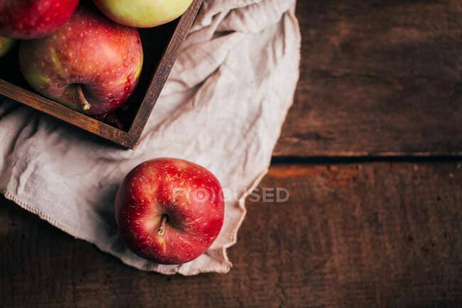 Manzanas rojas frescas en una caja en la mesa - foto de stock