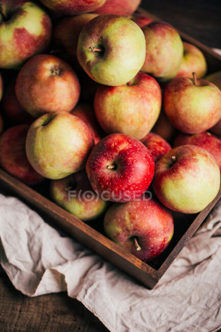 Pommes rouges fraîches dans une boîte sur la table — Photo de stock