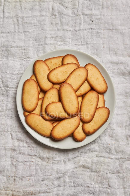 Top view of pile of delicious Christmas cookies placed on plate on tablecloth for holiday celebration — Stock Photo