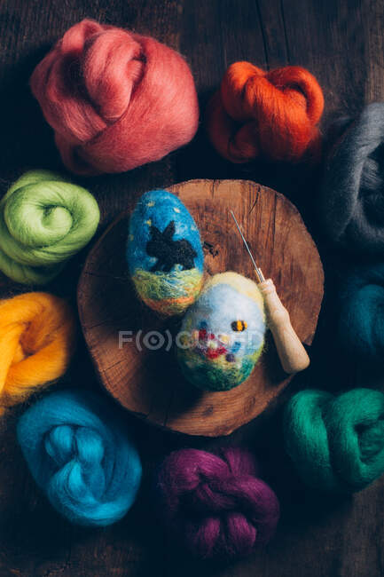 Пасхальные яйца ручной работы из шерсти и войлока на тёмном деревянном столе — стоковое фото