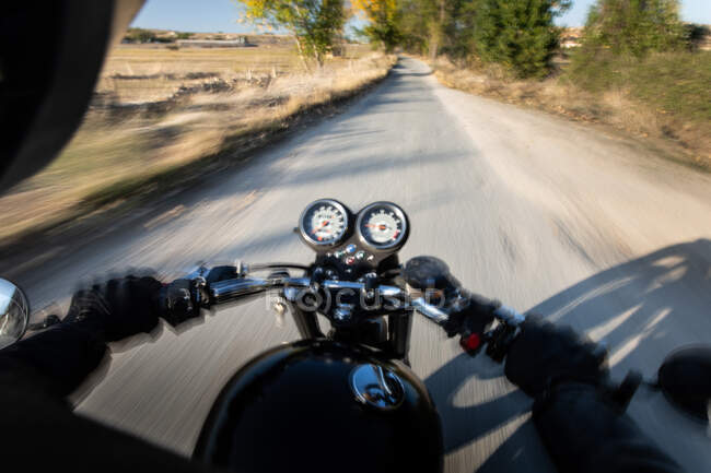 Visão traseira do piloto rápido sem rosto andando de moto através da floresta na localização rural — Fotografia de Stock